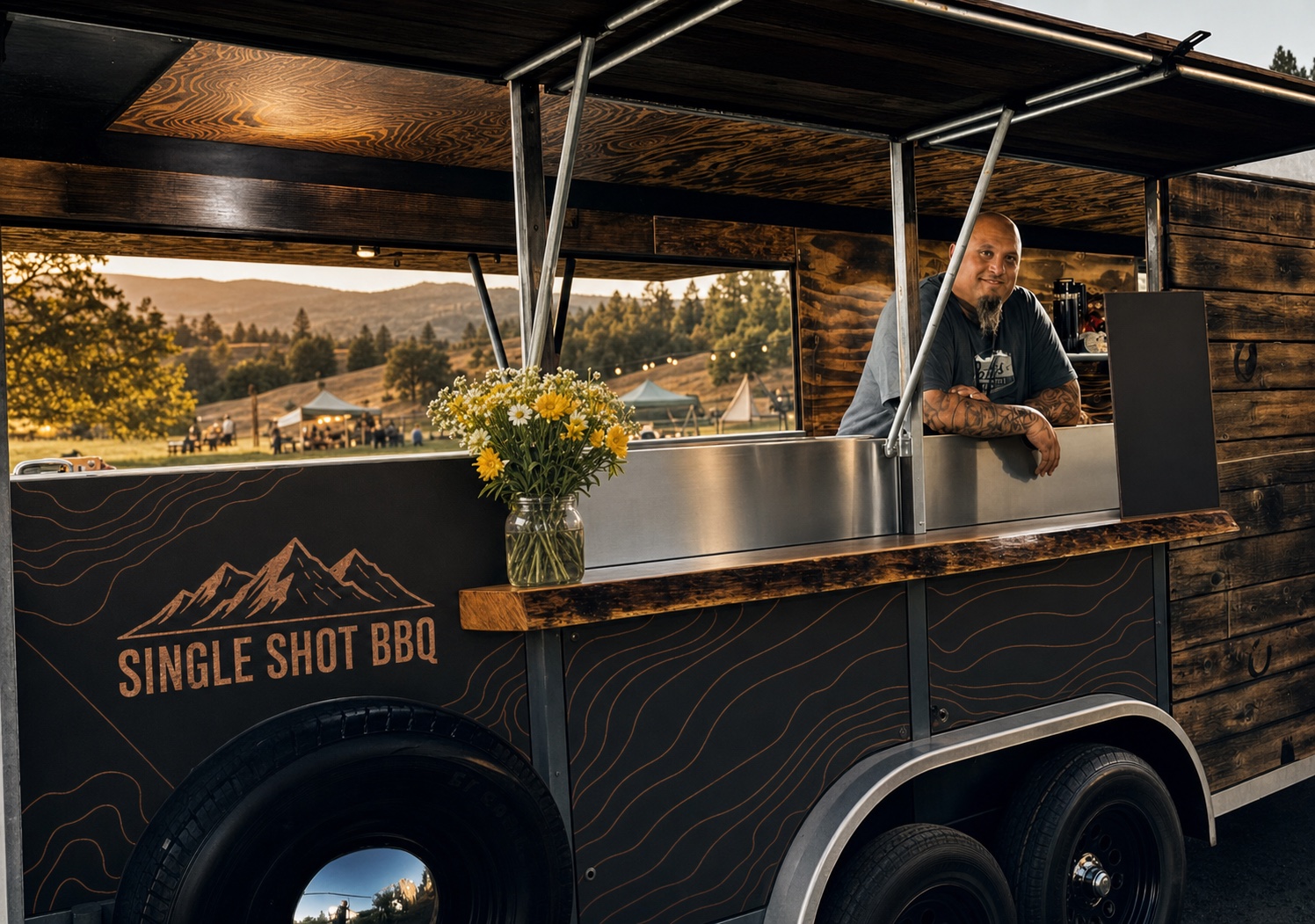 Eli at the nostalgic Single Shot BBQ trailer with refined black-and-copper panel graphics in a Northern California outdoor setting